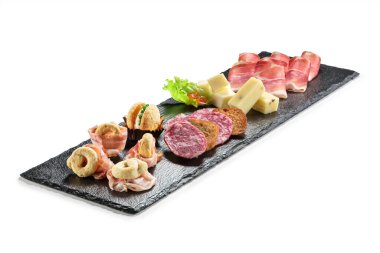 Siyah taş dikdörtgen tepside abur cubur lekeli pastırma taramili tuzlu makarna peyniri ve beyaz arka planda reçel.