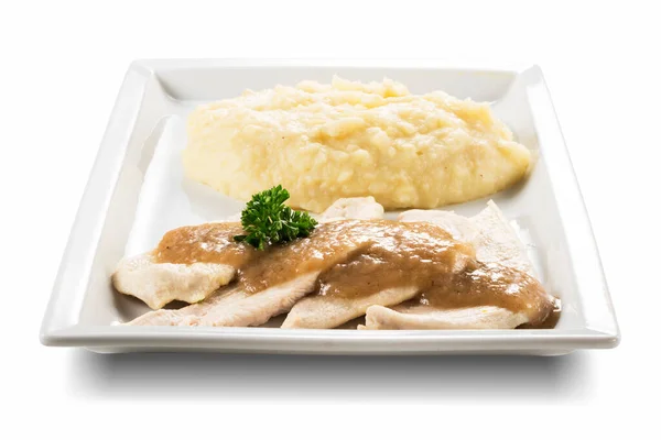 Rectangular plate with slices of white meat and mashed potatoes isolated on white background