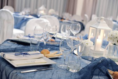 Bir düğün ziyafeti için mavi renk organzalı zarif bir masanın ayrıntıları