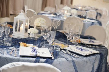 Bir düğün ziyafeti için mavi renk organzalı zarif bir masanın ayrıntıları