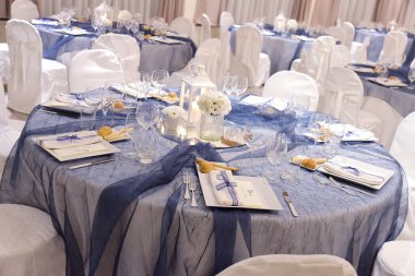 Bir düğün ziyafeti için mavi renk organzalı zarif bir masanın ayrıntıları