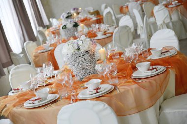 Zarif bir düğün ziyafeti için turuncu organzayla hazırlanmış bir masanın ayrıntıları.