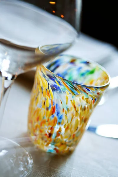 Detail of a hand-made glass of colored glass on a set table
