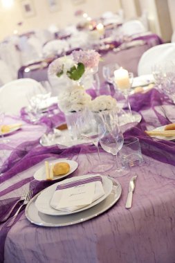 Detail of a table set in purple organza for a elegant wedding banquet