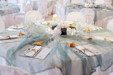 Detail of a table set in sea water color organza for a elegant wedding banquet