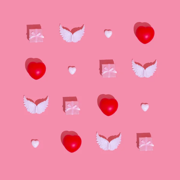 ピンクの背景にバレンタインデーのロマンチックなパターン ギフトボックス 天使の翼と心は最小のフラットレイアウトの愛の創造的な概念でグリッドを作っている — ストック写真