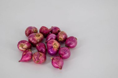 Seçici odaklı Küçük Kırmızı soğanlar beyaz arka planda izole. Küçük soğan aromalı kümelenmiş ampuller beyaz arka grubunda izole edilmiş baharatlar için kullanılır.