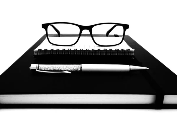 Stylo, defter, beyaz arka planda siyah beyaz okuma gözlükleri, Sekreterler Günü için yazma alanı olan teşekkür kartı, okul yılı sonu...