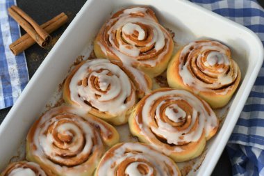 Kremalı ve tarçın çubuklu ev yapımı tarçın ruloları.