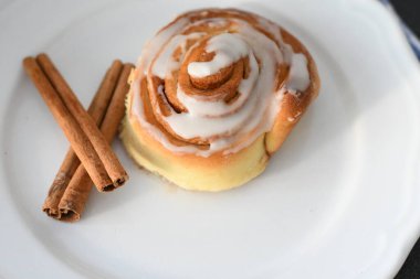 Kremalı ve tarçın çubuklu ev yapımı tarçın ruloları.