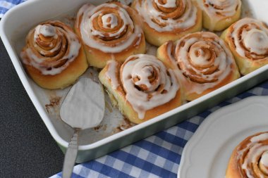 Kremalı ve tarçın çubuklu ev yapımı tarçın ruloları.