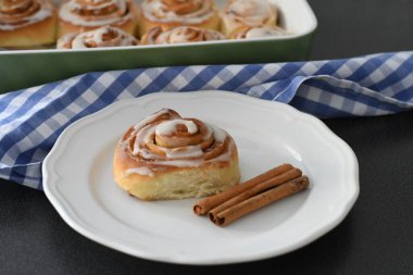 Kremalı ve tarçın çubuklu ev yapımı tarçın ruloları.