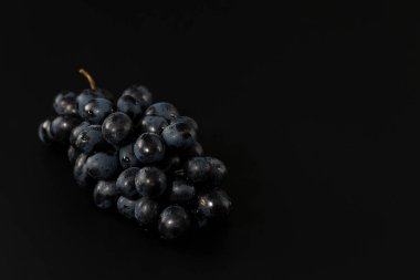Siyah arka planda siyah üzümler, sade anahtar