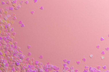 Pembe arka planda kalp şeklinde pul-konfeti. Sevgililer Günü konsepti