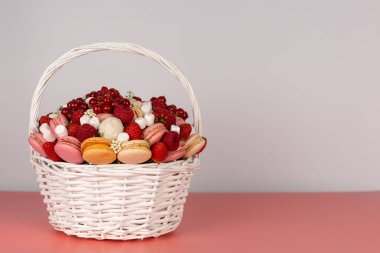 Böğürtlen ve tatlı dolu beyaz hasır sepet.