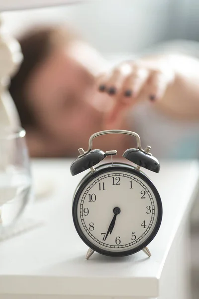 Young Woman Reaches Alarm Clock Turn Which Stands Bedside Table — Stock Photo, Image