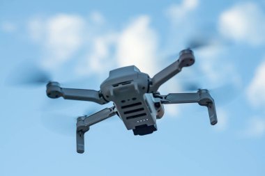 Consumer drone with camera hovering against sky