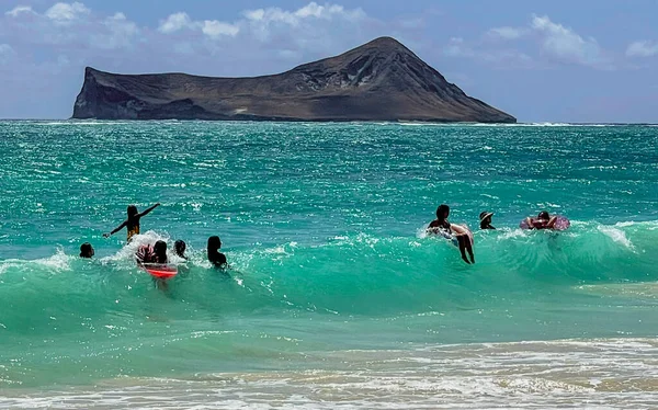 Jóvenes jugando en surf poco profundo en la playa de Oahu —  Fotos de Stock