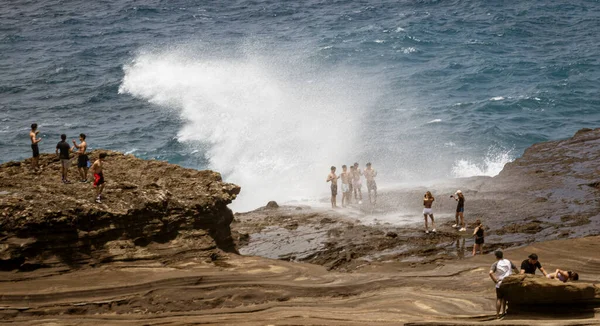 Honolulu, Hawaii - 6. Nov 2021-Menschen stehen auf Strandfelsen, als ihnen die Brandung über den Kopf geht — Stockfoto