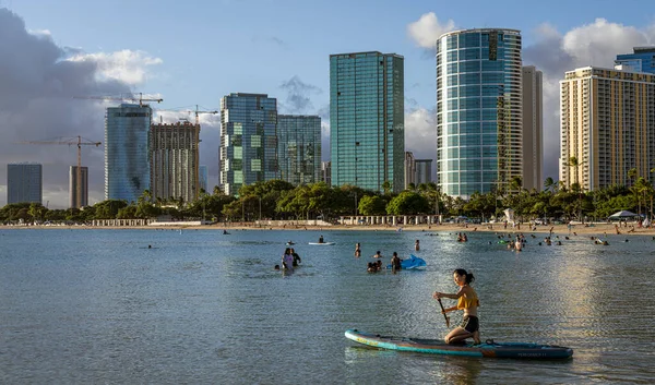 Honolulu, Hawaii - 6. Nov 2021-Menschen spielen im Wasser vor den Waikiki-Hochhäusern in Honolulu, Hawaii — Stockfoto