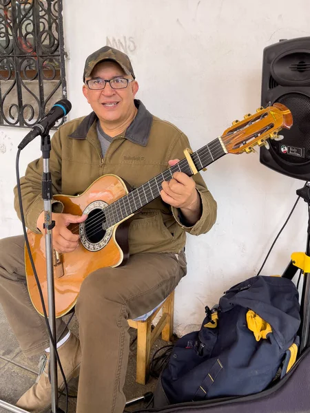 Cuenca, Ecuador, Dec 10, 2021 - man plays guitar as street musician for passing tips — Stok fotoğraf