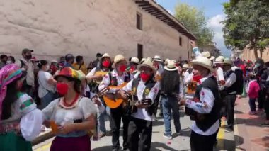 Cuenca, Ekvador, 24 Aralık 2021 Renkli COVID maskeli insanlar Noel geçit töreninde müzik ve dans ediyorlar.