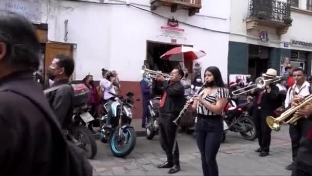Cuenca, Ecuador, 24 dec 2021 - Blaasinstrumenten spelen terwijl gemaskerde duivels dansen in een kerstparade. — Stockvideo