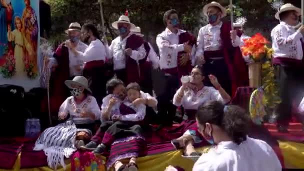 Cuenca, Ekvádor, 24.12.2021 - COVID maskované páry tleskají a pijí vodu na plováku na vánoční přehlídce. — Stock video