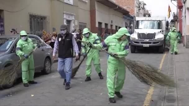 Cuenca, Ecuador, Dec 24, 2021 - COVID masked street sweepers clean up after a Christmas parade. — Stock Video