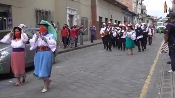 Cuenca, Ekvádor, 24. prosince 2021 - COVID maskovaní muži a ženy tančí a hrají na vánoční přehlídce. — Stock video