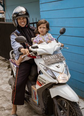 Central Kalamantan, Indonesia, May 20, 2022 - woman rides motorcycle with baby.