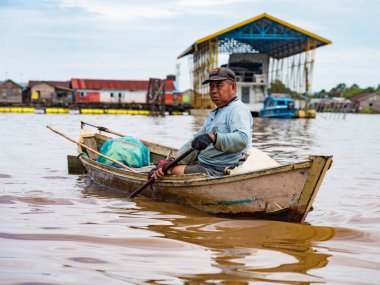 Central Kalamantan, Indonesia, May 20, 2022 - Man rows his boat across the river.