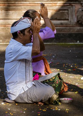 Two people prays at a Hindu shrine on Galungan Day.