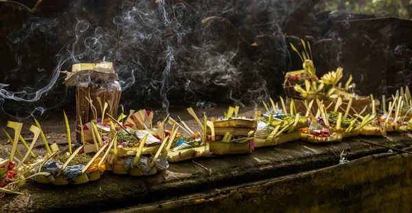Incense being burned in offering in several offering baskets.