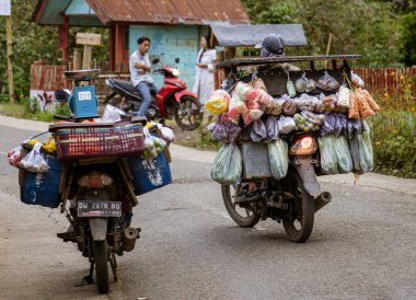 Indonesia, June 13 2022 - Motorcycles are loaded down with goods to sell when driven door-to-door in Indonesia.