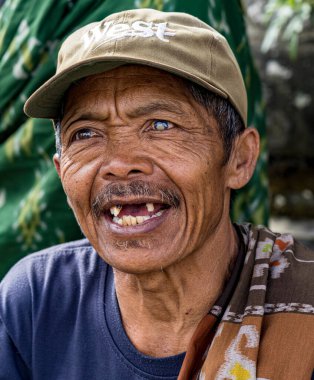 Indonesia, June 13 2022 - Old man with missing teeth smailes when talking.