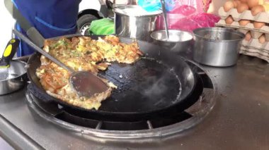 Malacca, Malezya 07172022-Jonker Caddesi Gece İstiridye Omleti Satıcısı tarafından pişiriliyor.