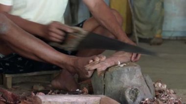 Lemo, Toraja, Endonezya 07042022-Man cenaze için tahta Tau Tau heykelini testereyle kesti..