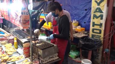 Malacca, Malezya 07172022-Jonker Caddesi Gece Satıcısı yumurta kabı pişiriyor.