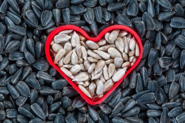 Ay çekirdeği. Kabuğu soyulmamış çekirdeklerden oluşan beyaz ayçiçeği tohumlarından yapılmış bir kalp.