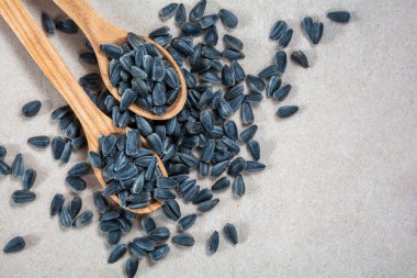 Tahta kaşıklarda ayçiçeği tohumları Ve ambalaj kağıdına saçılmış