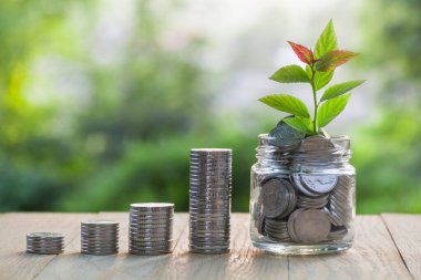 Columns of coins and accumulation of coins in a glass jar. The concept of financial growth. The concept of accumulation growth