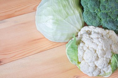 Ahşap arka planda çeşitli lahana. Beyaz lahana, karnabahar ve brokoli.