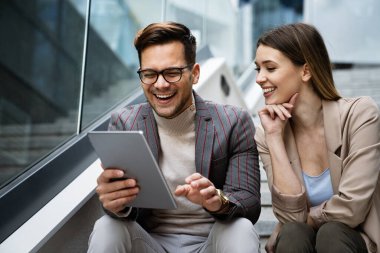 İş adamları, şehir planındaki işyerinde eğleniyor, çalışıyor ve sohbet ediyorlar.