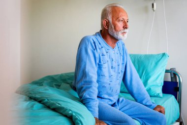 Hastalığını atlatmaya çalışan, hastane yatağında yatan ümitsiz bir erkek hasta. Sağlık hizmetleri, koronavirüs, insanlar konsepti.