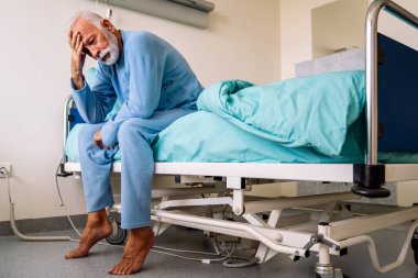 Hastalığını atlatmaya çalışan, hastane yatağında yatan ümitsiz bir erkek hasta. Sağlık hizmetleri, koronavirüs, insanlar konsepti.