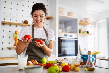 Mutfakta yemek yapan genç ve güzel bir kadın. Sağlıklı gıda, diyet, yaşam tarzı konsepti