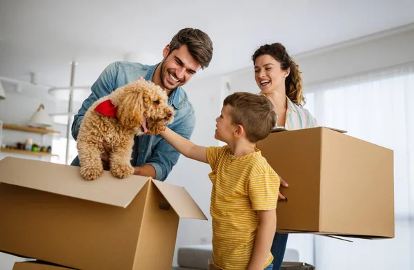 Happy young family with cardboard boxes in new house at moving day.