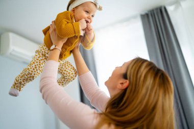 Genç anne evde bebeğiyle oynuyor. Mutlu aile kavramı