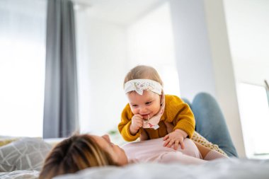 Mutlu bir aile. Anne kız oynuyor, sarılıyor, evde öpüşüyorlar.